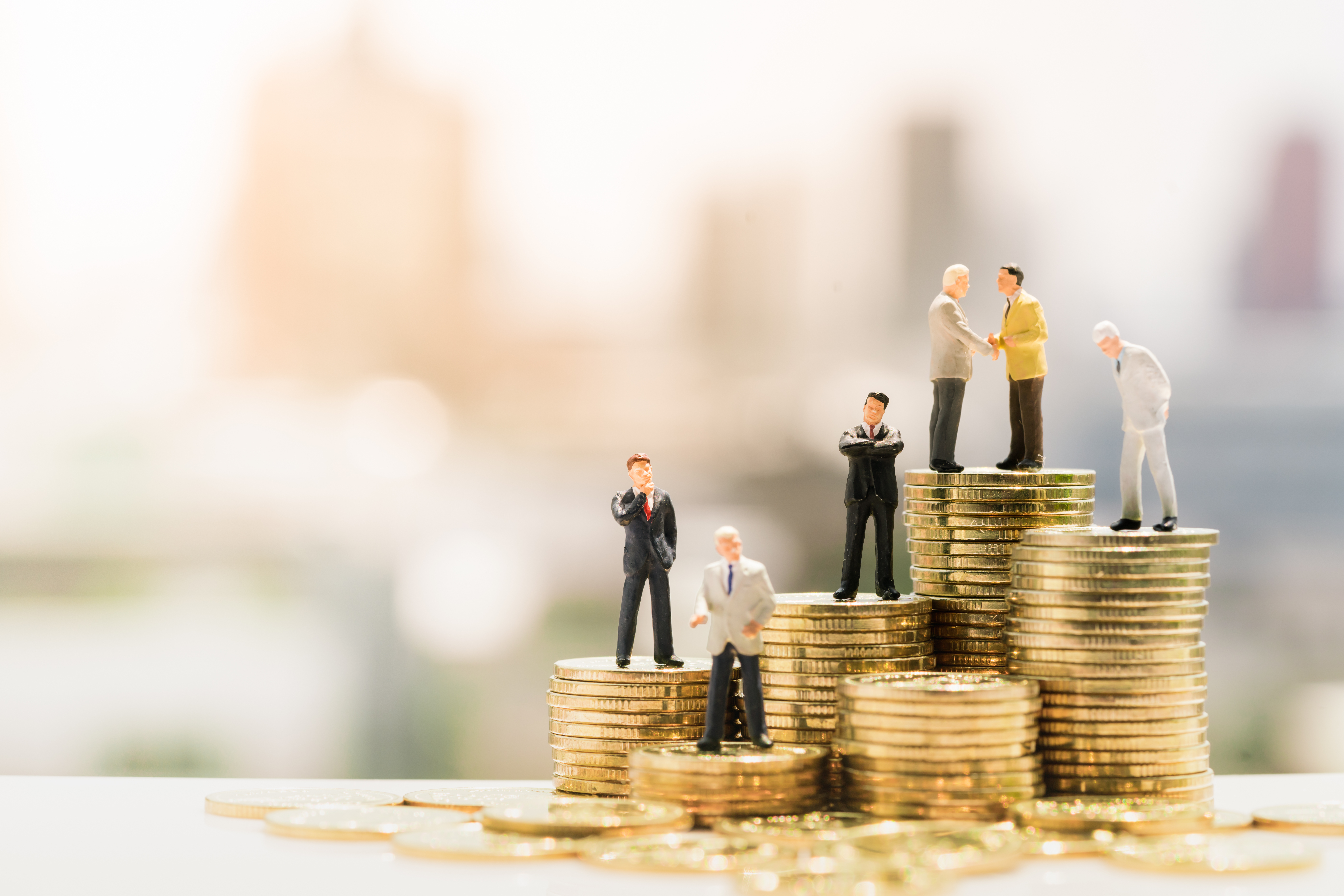 Miniature,People:,Small,Businessmen,Standing,On,Stack,Of,Coins,,Money,